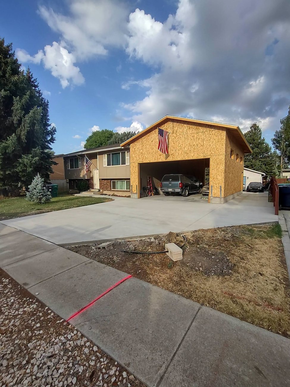 A freshly poured and broom finished concrete driveway on a Kaysville home