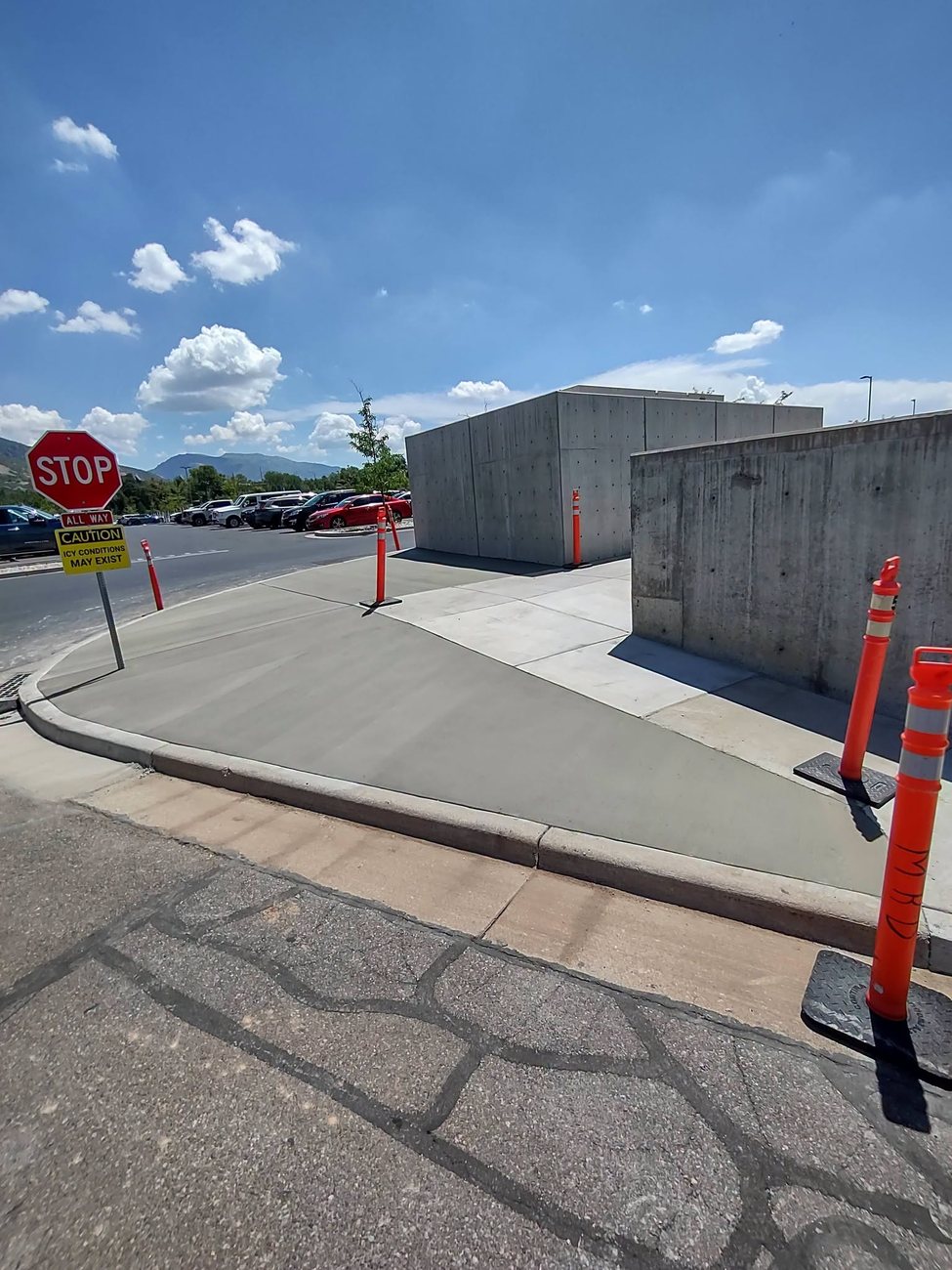 A poured concrete retaining wall holding back a graded yard
