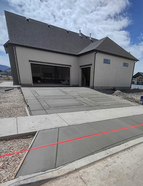 A freshly poured and broom finished concrete driveway on a Kaysville home