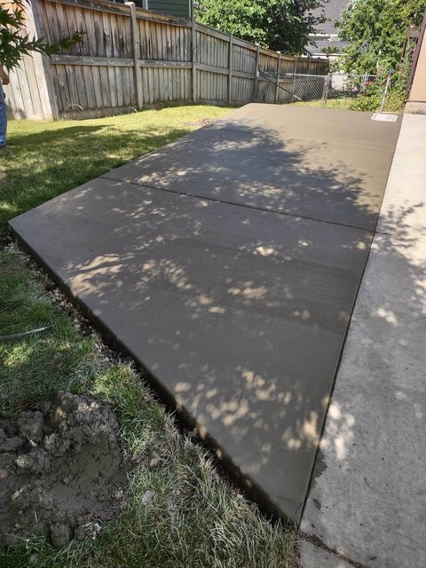 A smooth finished concrete walkway leading to a front entry