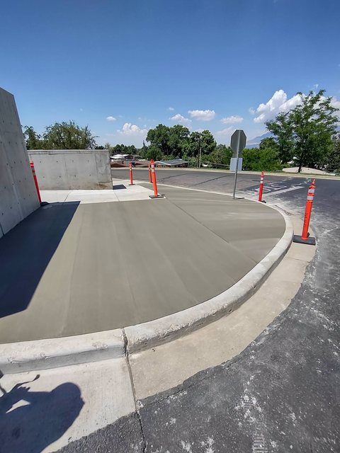 A poured concrete retaining wall holding back a graded yard